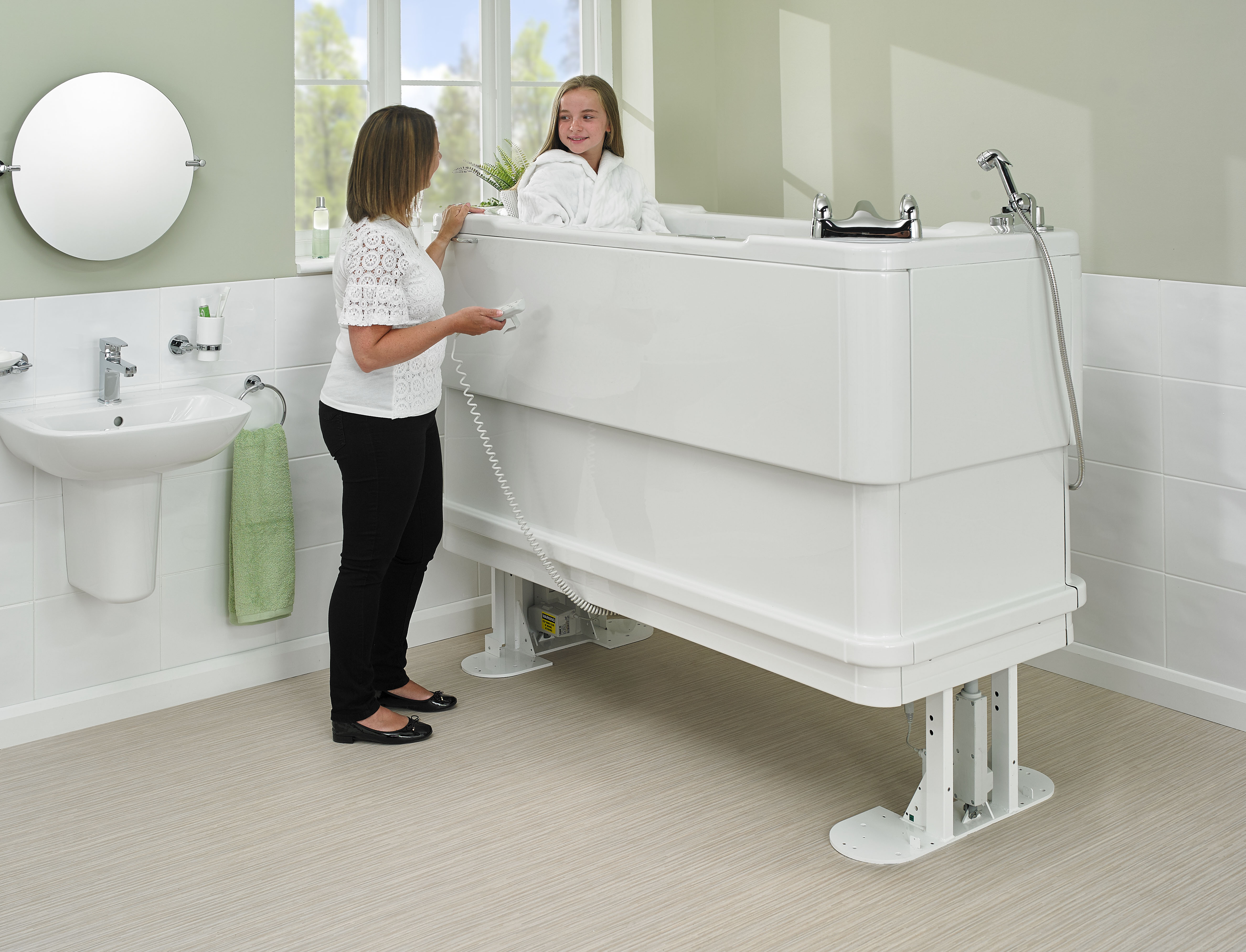 Girl in a Gemini 1700 adjustable height bath - raised position