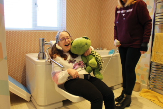 Karis cuddles her Trevor the Turtle, the Abacus company Mascot