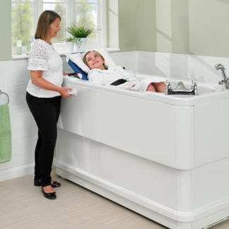 Girl in remote controlled height adjustable bath with her carer