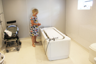 Powered adjustable height bath in wetroom - lowered position